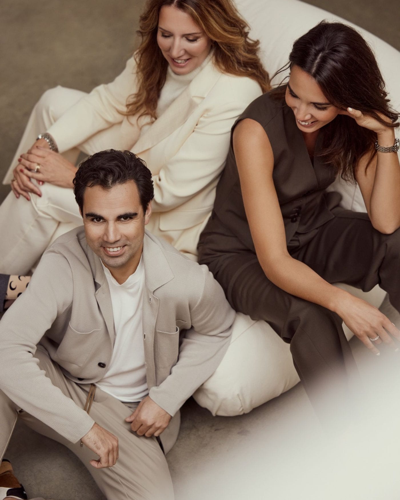 Drie modellen in crème en taupe op een lichte bank