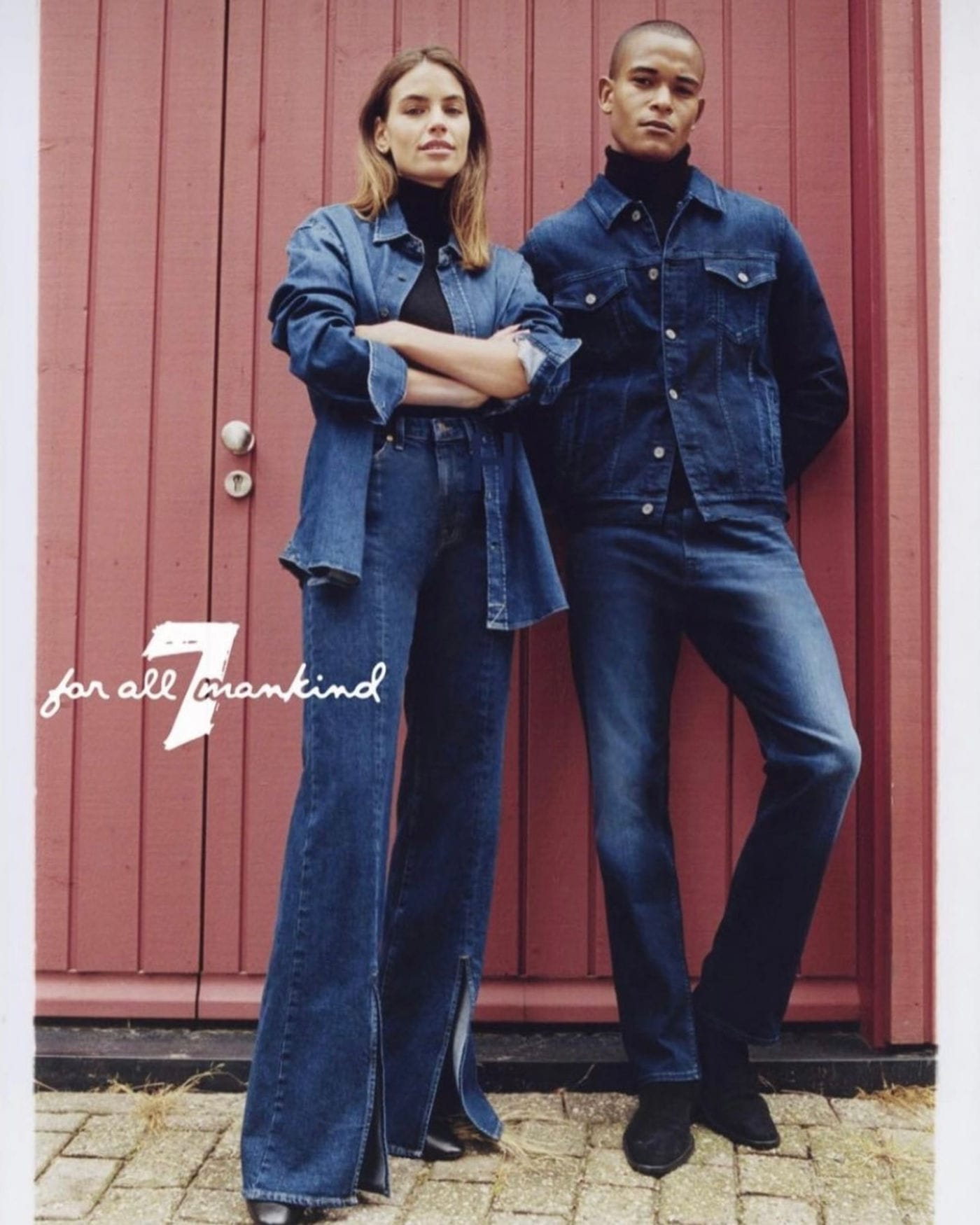 Twee modellen in denim voor een rode houten deur