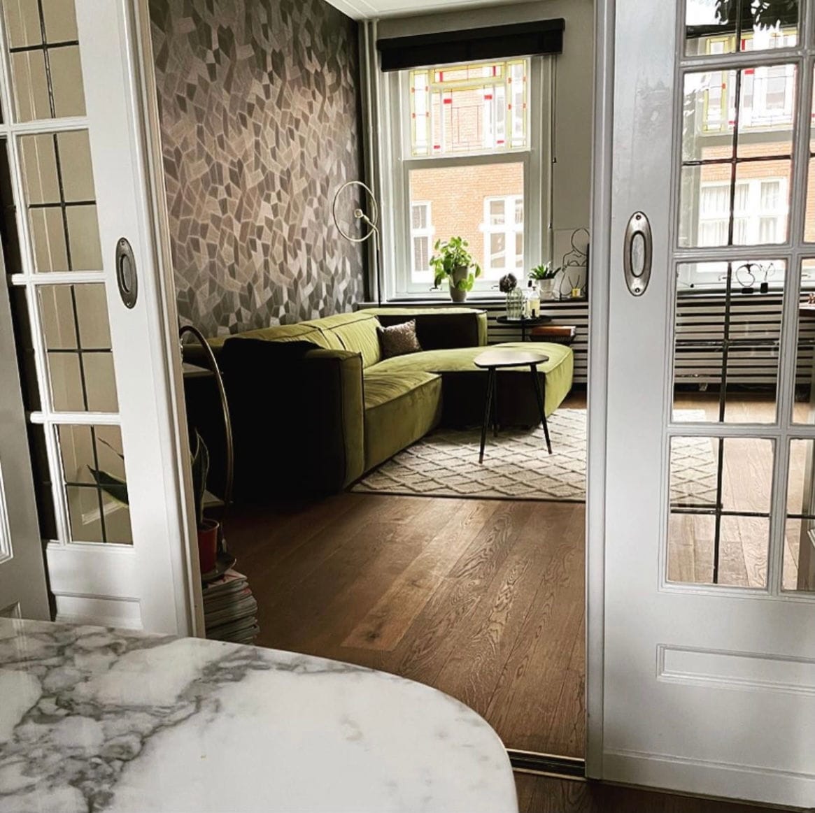 Appartement met groen velours, marmeren tafel en openslaande deuren